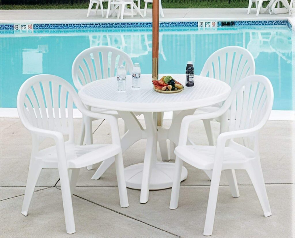 Grosfillex white resin table and armchairs on a resort pool deck